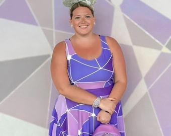Puede incluir: Un vestido sin mangas con un patrón geométrico en violeta y lavanda con líneas blancas que se cruzan, combinado con orejas de ratón de lentejuelas plateadas y una mochila a juego con patrón geométrico violeta y blanco y una pulsera.