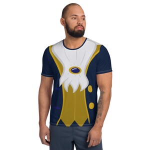 May include: A blue and gold t-shirt with a cartoon image of a prince's costume. The shirt features a white collar, gold vest, and blue jacket.