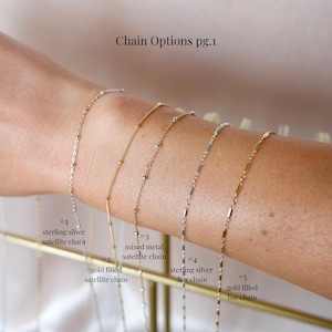 May include: A display of five delicate chain necklaces. The chains are silver and gold, with various designs including satellite and bar styles. The text "Chain Options pg.1" is at the top, with labels for each chain type.