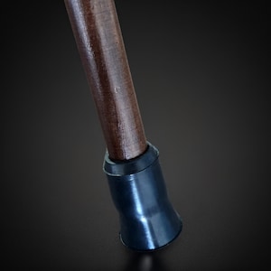 Puede incluir: Un bast&oacute;n de madera con una punta de goma negra. El bast&oacute;n es marr&oacute;n y tiene un acabado liso.