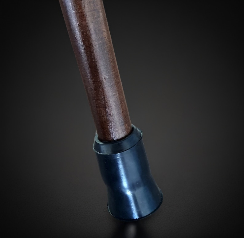 Puede incluir: Un bast&oacute;n de madera con una punta de goma negra. El bast&oacute;n es marr&oacute;n y tiene un acabado liso.