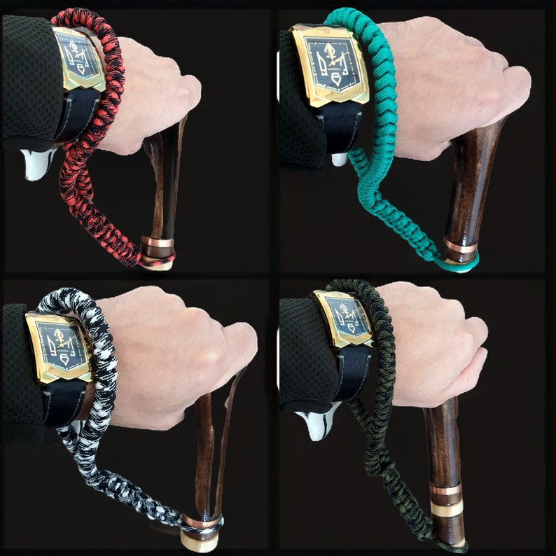 Puede incluir: Cuatro variaciones diferentes de un bast&oacute;n con una correa de mu&ntilde;eca decorativa y una esfera de reloj dorada. Las correas son roja, verde, negra y blanca, y azul.
