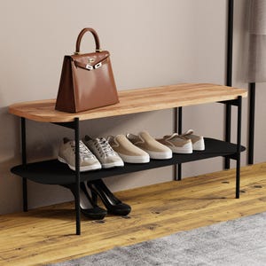 Könnte beinhalten: Ein zweistöckiges Schuhregal mit einer Ablage in heller Holzoptik und einem schwarzen Metallrahmen. Auf der oberen Ablage steht eine braune Ledertasche. Das untere Regal bietet Platz für vier Paar Schuhe, darunter Sneaker und Pumps.