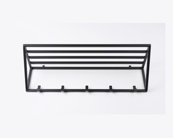 May include: Black metal wall-mounted coat rack with five hooks and a shelf.