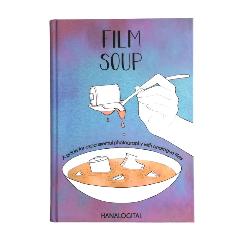 May include: A book cover with a purple and blue gradient background. The title "FILM SOUP" is written in black text. An illustration shows a hand pouring a film canister into a bowl of orange liquid. The text below the illustration reads "A guide for experimental photography with analogue films". The bottom of the cover reads "HANALOGITAL".