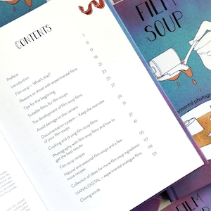 May include: A book titled "Film Soup" with a table of contents listing chapters and page numbers. The book cover features a hand holding a spoon dipping into a can of film soup.