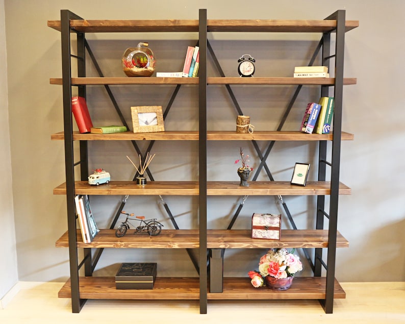 Pode incluir: Uma estante de metal preto e madeira com seis prateleiras. As prateleiras est&atilde;o cheias de livros, itens decorativos e uma pequena planta em vaso.