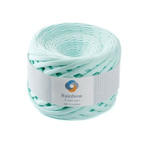May include: A roll of light blue t-shirt yarn, made from 100% cotton. The yarn is wound around a white cardboard tube with a label that reads "Rainbow T-shirt yarn 100% cotton".