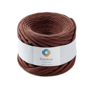 May include: A brown ball of t-shirt yarn made from 100% cotton. The yarn is labeled "Rainbow T-shirt yarn 100% cotton".
