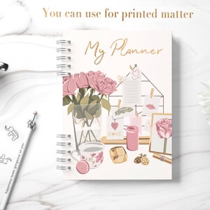 Peut inclure: Un agenda rose et blanc avec le texte "My Planner" sur la couverture. L'agenda pr&eacute;sente un motif floral avec des roses roses, une tasse &agrave; th&eacute; et une bougie. L'agenda est parfait pour organiser vos t&acirc;ches quotidiennes et vos rendez-vous.