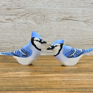 A pair of blue jays, two wooden birds, carved birds.