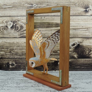 Barn owl in a window, a wooden sculpture of an owl, a carved bird.