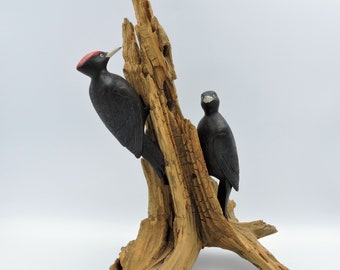 A pair of black woodpeckers, a wooden sculpture of birds.