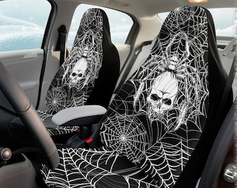 May include: Two black car seat covers with a white spider web design and a skull in the center. The spider web design is intricate and detailed. The skull is white and has a black outline. The seat covers are made of a soft, comfortable material and are easy to install.