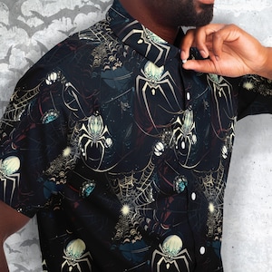 May include: A black button-up shirt with a spiderweb and spider pattern. The shirt has a dark background with a light yellow spiderweb and white spiders.