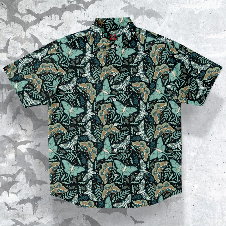 Puede incluir: Una camisa de manga corta con botones y un estampado de polillas y hojas en verde oscuro y marr&oacute;n. La camisa tiene un cuello cl&aacute;sico y cierre de botones.
