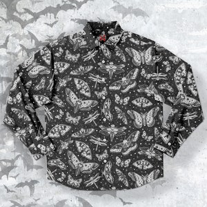 Op de afbeelding: Een zwart lang mouw overhemd met knopen en een witte print van verschillende insecten, waaronder vlinders en libellen.