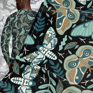 May include: A black fabric with a repeating pattern of green and brown moths on a black background. The moths have intricate details and are surrounded by green leaves.