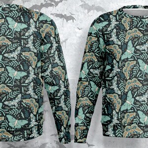 May include: A black sweatshirt with a repeating pattern of green moths and leaves. The moths have brown and green wings and the leaves are a dark green.
