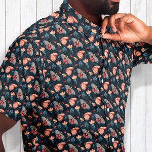 May include: A dark blue button-up shirt with a repeating pattern of colorful butterflies and flowers.