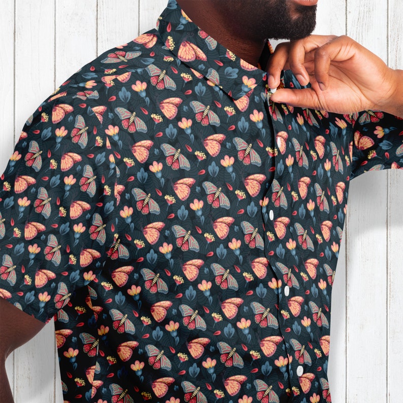 May include: A dark blue button-up shirt with a repeating pattern of colorful butterflies and flowers.