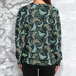 May include: A black sweatshirt with a repeating pattern of green and brown moths on a dark background.