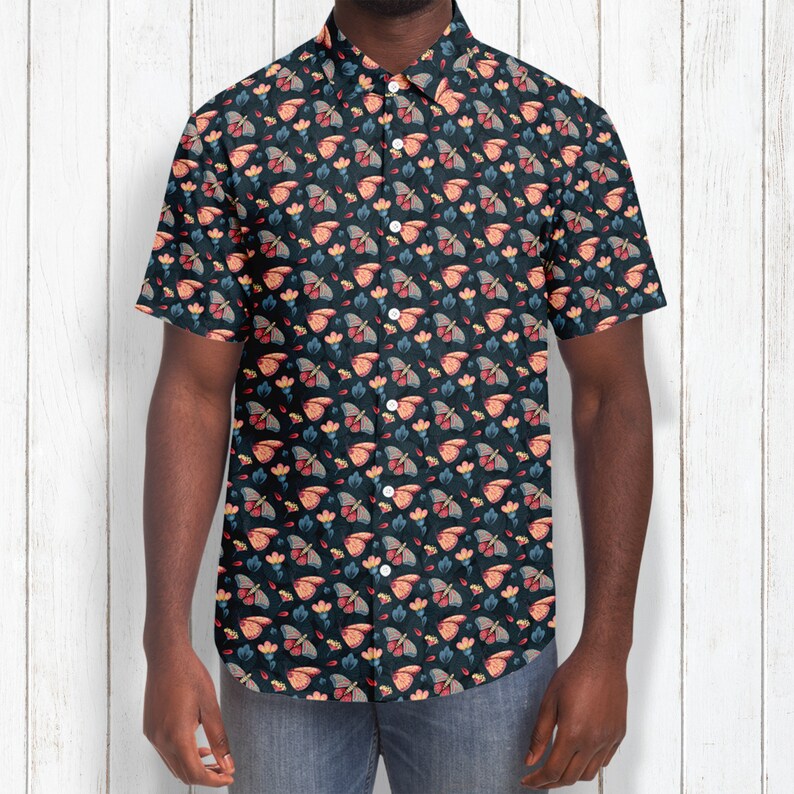 May include: A short-sleeved button-down shirt with a dark blue background and a repeating pattern of colorful butterflies and flowers.