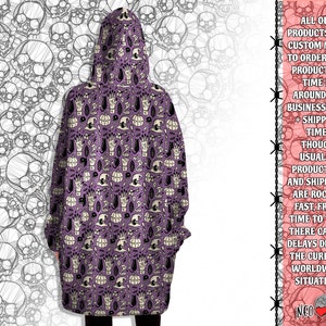 May include: Purple hooded sweatshirt with a repeating pattern of white skulls, pumpkins, hands, and other Halloween-themed imagery.