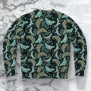May include: A black sweatshirt with a repeating pattern of green and brown moths on a dark background. The moths have large, intricate wings and are surrounded by leaves and vines.