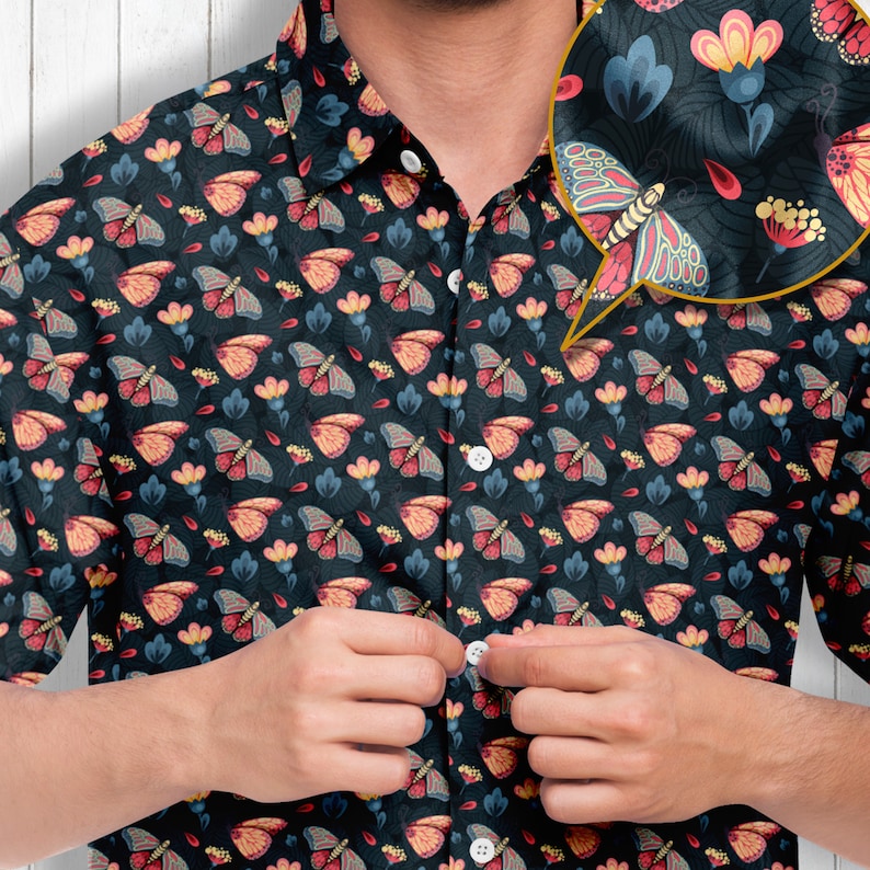 May include: A dark blue short-sleeved button-down shirt with a repeating pattern of butterflies and flowers. The shirt has a button-up collar and a pocket on the left side.