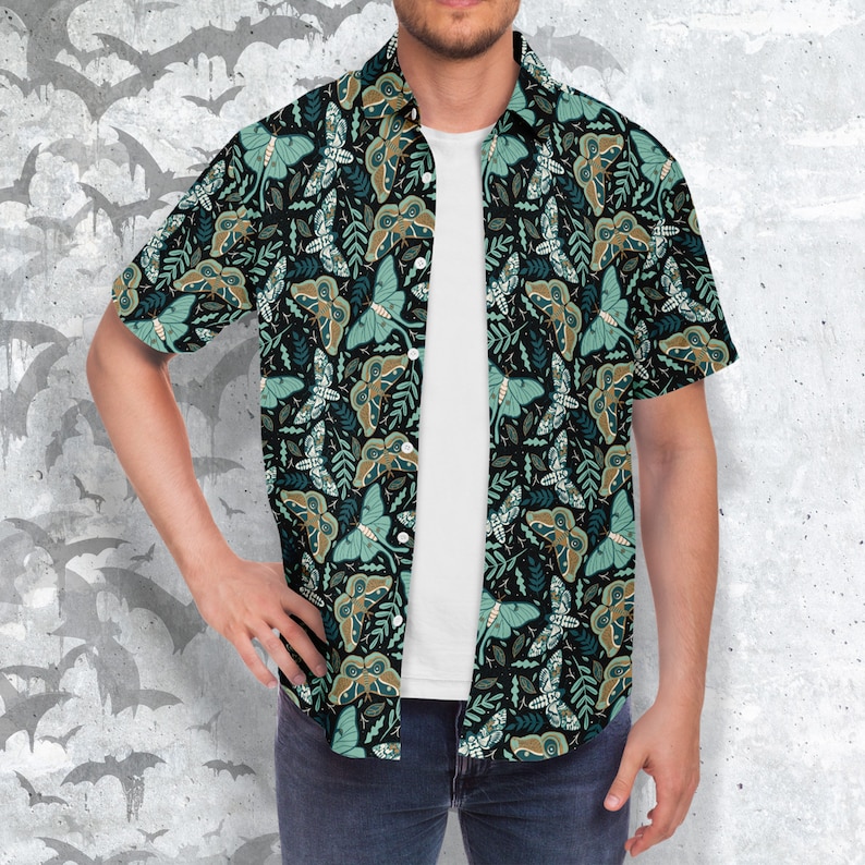 Puede incluir: Una camisa de manga corta con botones, fondo negro y un patr&oacute;n repetido de polillas verdes y marrones y hojas.