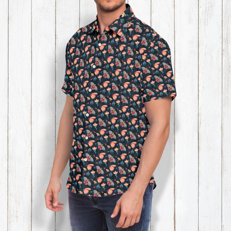May include: A short-sleeved button-down shirt with a dark blue background and a repeating pattern of colorful butterflies and flowers.