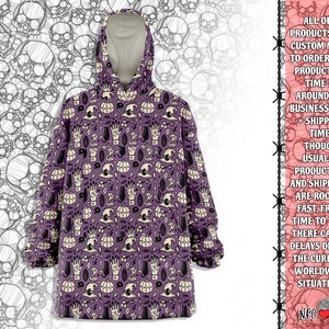 May include: Purple hooded sweatshirt with a black and white print of various Halloween themed symbols, including skulls, pumpkins, and witches' hats.