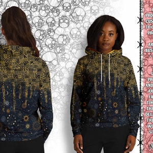 May include: A black hoodie with a gold and black celestial print. The print features stars, moons, and suns. The hoodie has a drawstring hood and a kangaroo pocket.