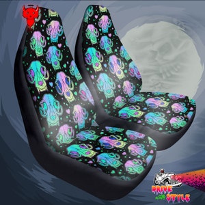 May include: Two black car seat covers with a colorful skull and heart pattern. The pattern is on a black background with pink, blue, green, and purple skulls and hearts.