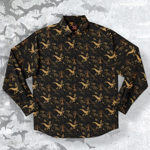 May include: A black long-sleeve button-up shirt with a gold whale, tree, and star pattern.