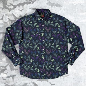 May include: A long-sleeved button-down shirt with a dark blue background and a repeating pattern of bats, moons, and stars in shades of purple, green, and blue.