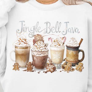 Peut inclure: Sweat-shirt blanc avec l'inscription "Jingle Bell Java". Le motif présente des boissons au café avec de la crème fouettée, des bonhommes en pain d'épices et des cannes en sucre, parfait pour les fêtes de fin d'année.