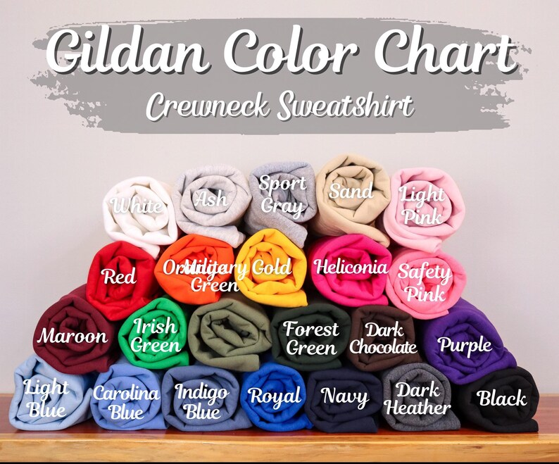 Peut inclure: Un nuancier pour les sweatshirts Gildan. Le tableau pr&eacute;sente une vari&eacute;t&eacute; d'&eacute;chantillons de tissu roul&eacute;s dans des couleurs telles que le blanc, le rouge, le marine et le noir. Des &eacute;tiquettes de texte identifient chaque couleur.