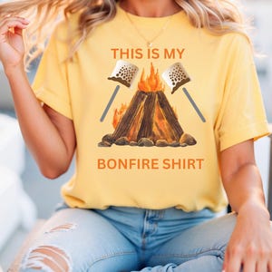 May include: Yellow t-shirt with a campfire graphic and the text "This is my bonfire shirt".