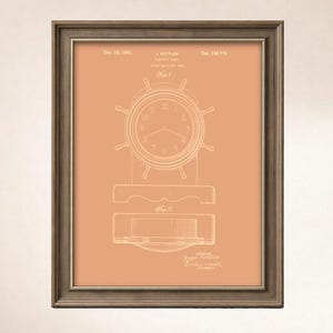 May include: Framed vintage clock patent art print. The clock design is in white on a peach background, with a dark brown frame. The clock face is round with a ship's wheel design. The print includes text and technical drawings.