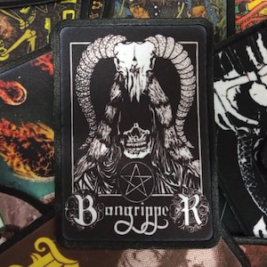 Op de afbeelding: Zwart-witte geborduurde patch met een schedel die een capuchon en hoorns draagt. De schedel heeft een pentagram op zijn voorhoofd. De tekst "Bangrippe R" staat onder de schedel.
