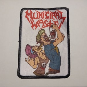 May include: Rectangular patch with the text "MUNICIPAL WASTE" in red, stylized lettering. The patch features a graphic of two figures drinking from a can. One figure is wearing a green hat and the other has a pink mohawk. The patch has a black border.