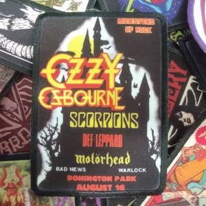 May include: A black and white patch with a castle silhouette and the text "Monsters of Rock", "Ozzy Osbourne", "Scorpions", "Def Leppard", "Motörhead", "Bad News", "Warlock", "Donington Park", and "August 16".