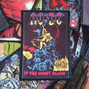 May include: A black and white iron-on patch featuring the band AC/DC's logo and the text "If You Want Blood".