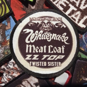 Può includere: Un cerotto rotondo ricamato bianco e nero con il testo "Monsters of Rock" in alto, "Whitesnake", "Meat Loaf", "ZZ Top" e "Twisted Sister" in un cerchio.