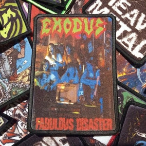 May include: A black and red embroidered patch with the band name "Exodus" and the album title "Fabulous Disaster" in white text. The patch features a photo of the band in a dark room with a red light.