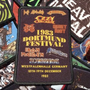 May include: A black patch with yellow text that reads "1983 Dortmund Festival". The patch features the logos of several bands, including Iron Maiden, Scorpions, Judas Priest, Ozzy Osbourne, and Krokus. The patch also includes the text "Westfalenhalle Germany 18th-19th December 1983".