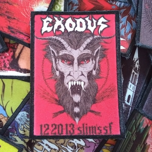 May include: A red and black embroidered patch with the band name "EXODUS" in white lettering. The patch features a black and white illustration of a demon with horns and fangs. The text "12.20.13 Slim's SF" is printed in white at the bottom of the patch.