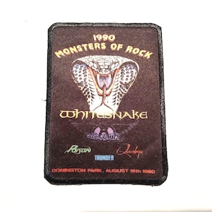 May include: A black and brown patch featuring a cobra snake graphic and the text "1990 Monsters of Rock Whitesnake Donington Park, August 18th 1990". The patch also includes the names of other bands: "Poison", "Thunder", and "Queensryche".